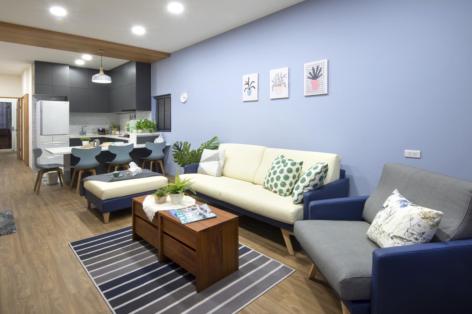 客廳45度角拍攝，右邊藍牆加三人座沙發再搭配一張單人沙發